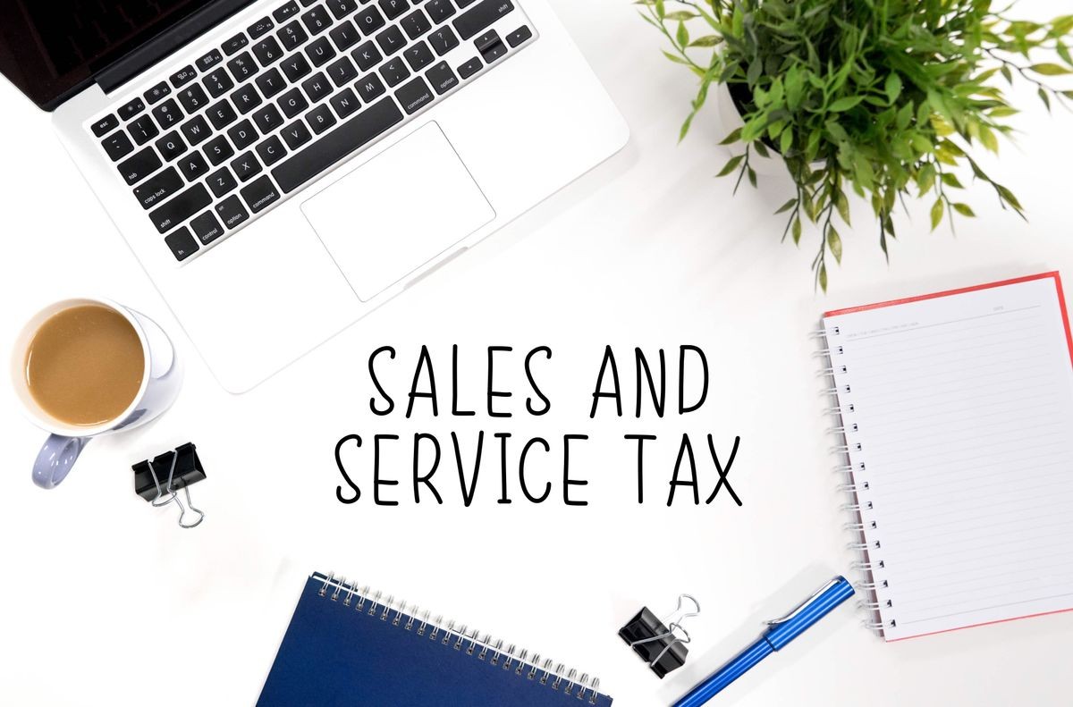 Sales and service tax concept with laptop, notebook, cup of coffee and pen
